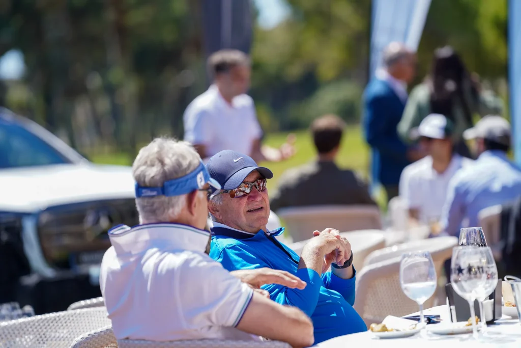 Invitados de un torneo de golf de empresa en la terraza del club